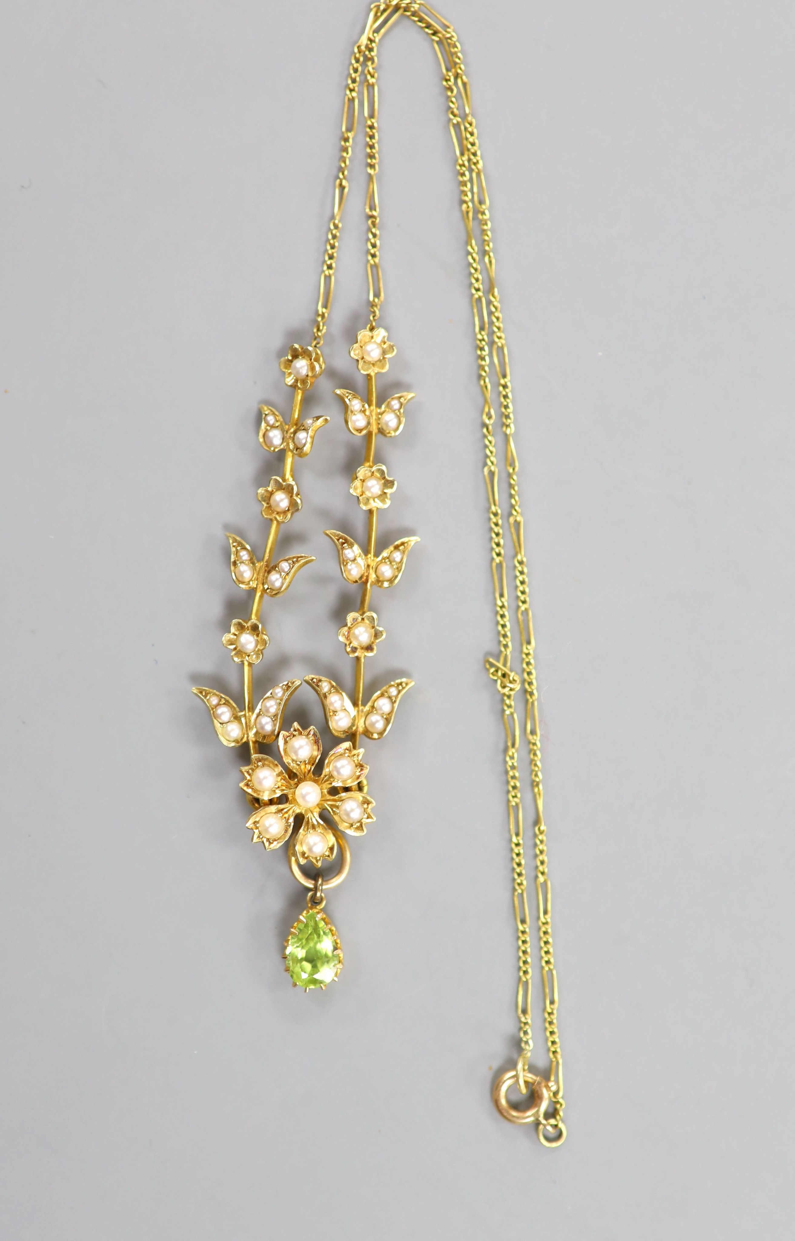 An Edwardian 15ct, seed pearl and pear cut peridot drop set necklace, 40cm